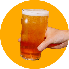 Hand holding ice cold beer with yellow background
